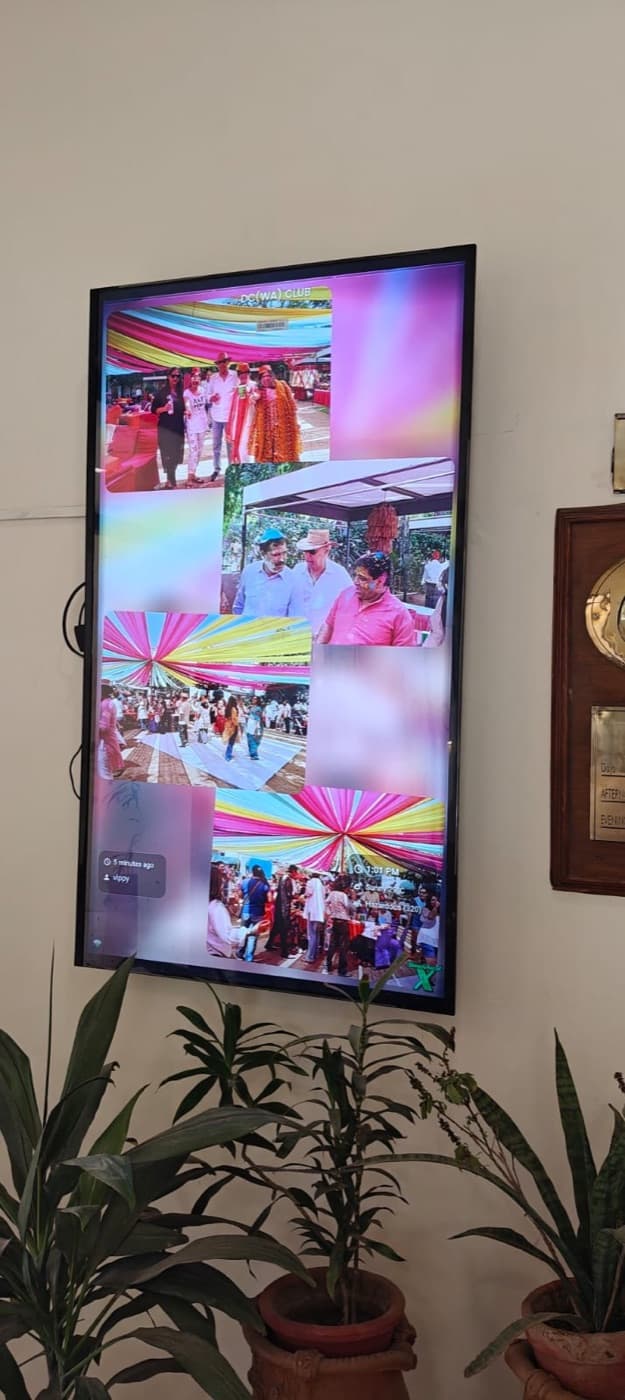 A wall-mounted portrait screen at The Defence Colony (WA) Club, showing a photo collage from a club event